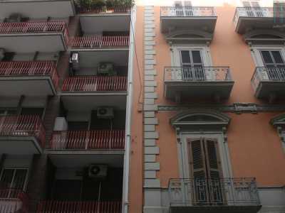 Foto 10. Siamo ora in via Davanzati, dove ci ritroviamo davanti a un altro condominio kitsch creato con mattonelle scure e ringhiere dei balconi rosse, costellato da numerosi condizionatori, adiacente a un grazioso edificio antico color salmone con raffinati timpani arrotondati 